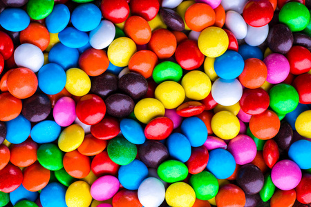 彩色巧克力糖果丸。糖果变化颜色纹理或背景。俯视图