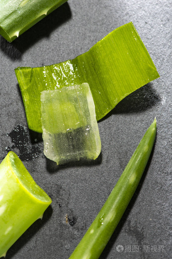 芦荟片在黑暗的背景上健康和美丽的概念背光上特写芦荟片