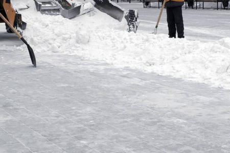 市政城市道路养护..拖拉机从城市的积雪中清扫街道..工作铲子耙雪。暴风雪过后打扫卫生。复制空间。