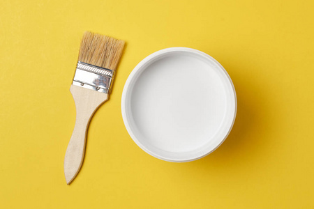 在黄色背景上, 用白色的颜色刷和油漆罐, 顶部视图