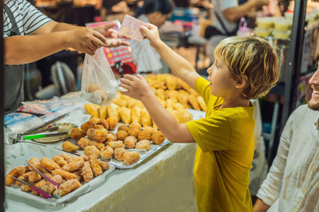 爸爸和儿子是亚洲食品市场步行街上的游客