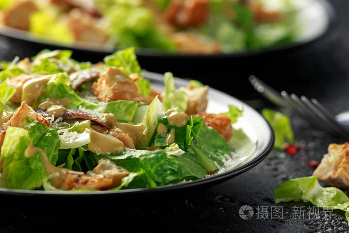 凯撒沙拉配鸡肉凤尾鱼面包帕玛森奶酪和青菜。健康食品