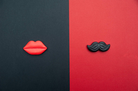 男性和女性的概念。 平躺着红色和黑色的红色嘴唇和黑色的胡子，作为男人和女人的象征。 情人节