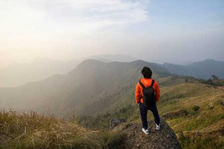 年轻的旅行者站在山顶看美丽的风景