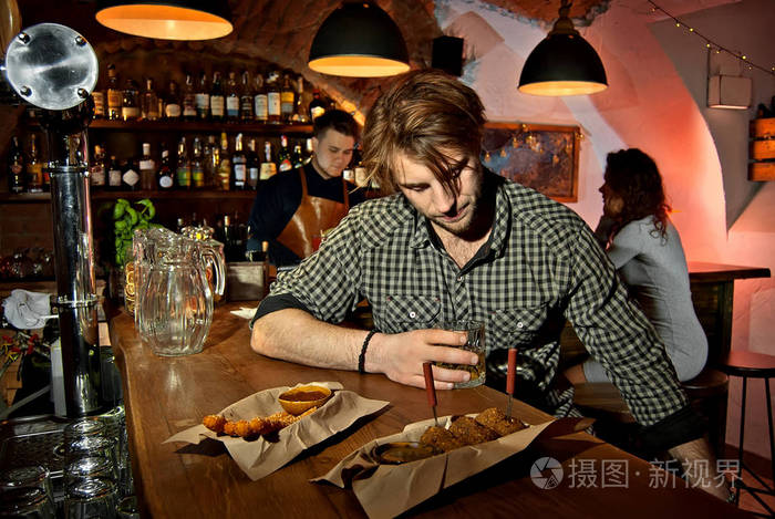 男孩和女孩在酒吧休息. 两个人喝酒. 背景中的酒保.