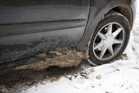肮脏的汽车轮胎和雪。 化学试剂