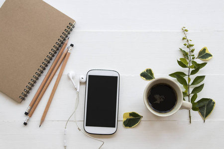 笔记本电脑规划师手机，商务工作，热咖啡和叶子装饰平躺风格的背景白色。