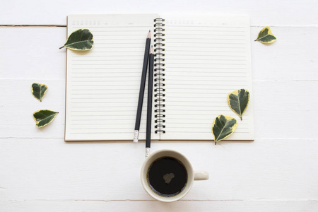 笔记本电脑规划师，商务工作，热咖啡和叶子装饰平躺风格的背景白色。