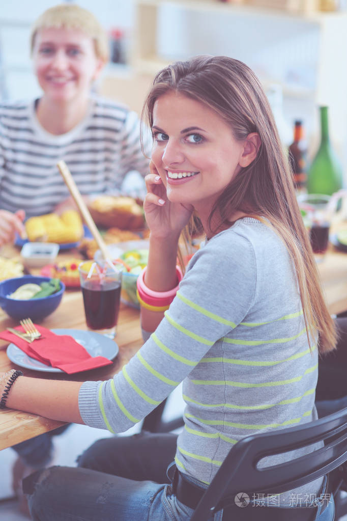 照片 坐在木桌边吃饭的一群人的最高视图.餐桌上的食物.人们吃快餐.