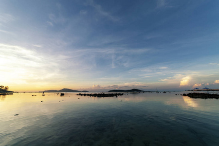 戏剧性的天空海景与岩石在日出的风景和美丽的倒影在海洋。