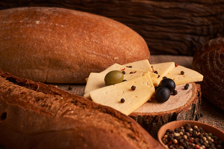 传统的荷兰式半硬奶酪，在乡村餐桌上提供橄榄，并在餐桌上进行包装