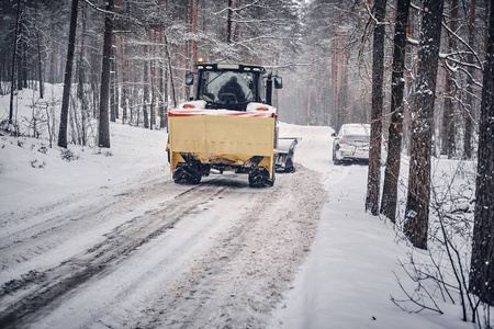 推土机清理覆盖雪的道路穿过森林