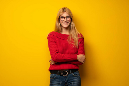 金发女人戴着眼镜在黄色的墙上微笑