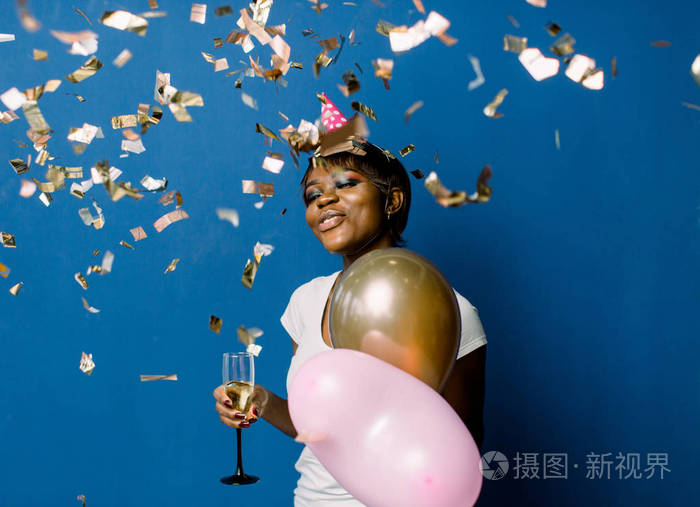 扔纸屑庆祝生日室内照片漂亮的黑人女士拿着香槟和气球脸上表情很高兴