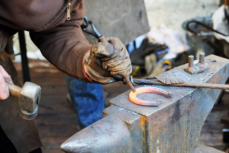 铁匠在锻铁砧上用锤子加工金属