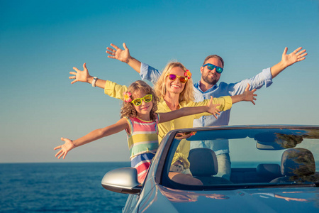 幸福的家庭坐车旅行。 人们在蓝色的敞篷车里玩得很开心。 暑假概念