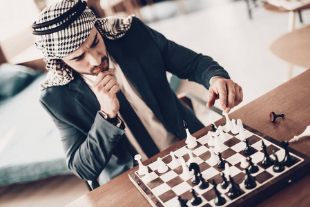 阿拉伯商人。 穿着黑色西装的人。 有经验的企业家。 成功的年轻人。 阿拉伯的肖像。 很好的休闲。 阿拉伯人下棋。 人的计划策略。