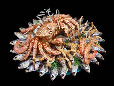 大毛煮蟹坐在一堆干咸鱼上，放在黑色背景的礼物花束上