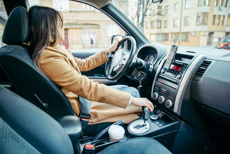 年轻女子驾驶汽车，用手机导航。 公路旅行