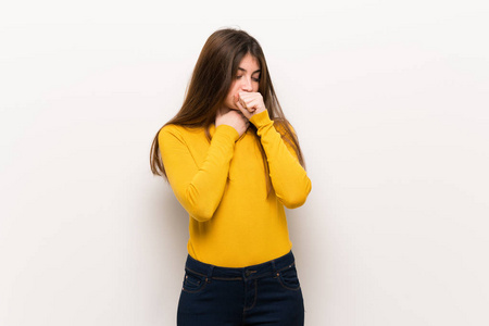 穿黄色毛衣的年轻女子咳嗽，感觉不好