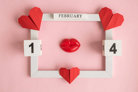 假日摘要由2月14日木日历的相框14和红色纸心与塑料嘴唇玫瑰。