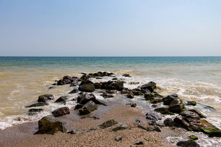 海边有石头，海浪干净，碧水蓝天的背景。 美丽的夏海海岸。 旅游和度假季节。