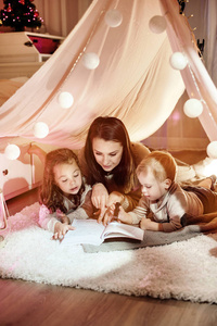 年轻的母亲和孩子们一起读小说
