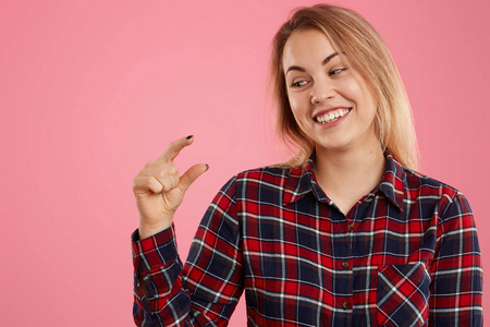 假装开心快乐的女人,有着一头轻盈的短发,积极地微笑着,穿着格子衬衫