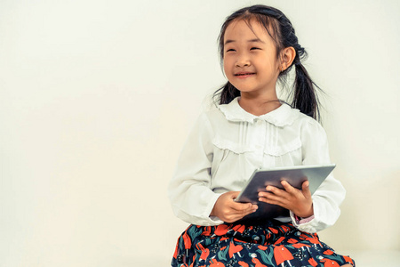 白色背景上带平板电脑的小快乐孩子。 童年生活方式。