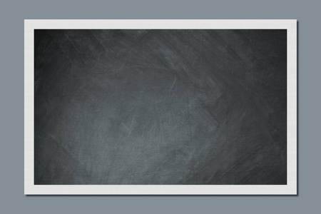 空白黑板挂在教室的灰色墙上。 教育和学校观念。 为您的信息或广告留出空位。