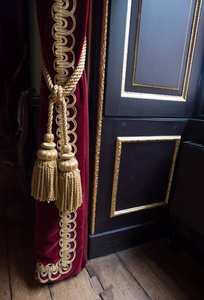 金绳，华丽的流苏，挂着红色天鹅绒帘