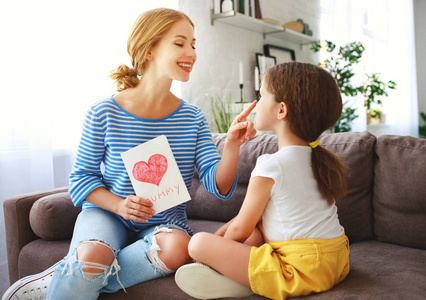 s day Child daughter congratulates moms and gives her a postcar