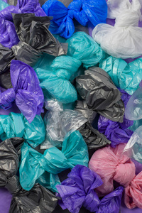 明亮的多色塑料垃圾袋卷成蝴蝶结顶视图