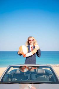海滩上成功的年轻女商人。 站在敞篷车经典车里的女人。 暑假和自由旅行概念