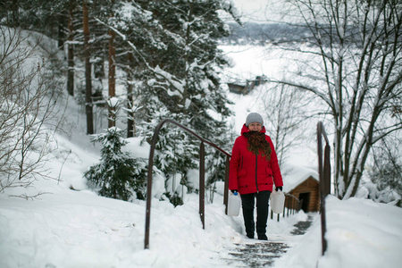 在下雪的冬天，俄罗斯村庄的街道上的女人。