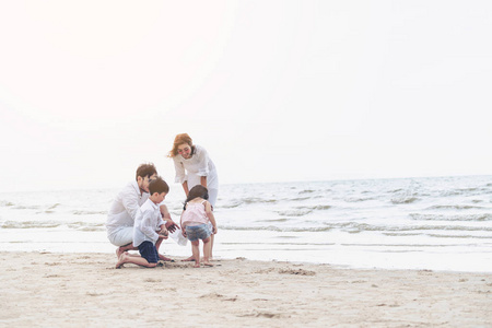 爸爸妈妈和孩子们的幸福家庭在夏天去热带沙滩度假。