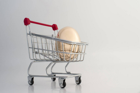 一个金色的鸡蛋，由金属制成，在一个渐变的浅灰色背景下。 为客户提供独特报价的概念。 复制空间。