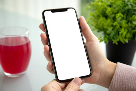 在夏天的咖啡馆里,一只手拿着手机,屏幕隔离屏幕的手机照片