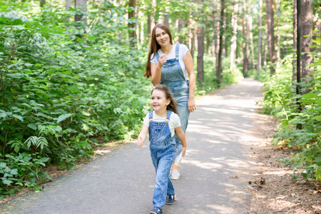 家庭儿童和自然概念母亲与她的孩子女孩在绿色的夏季公园玩耍和散步