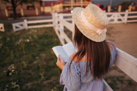 后面的美丽孕妇阅读农场上的书。她站在法朗斯旁边, 看着这本书。放松