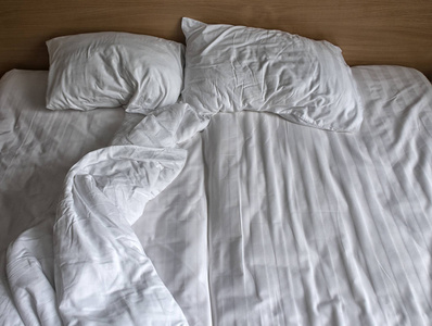 白色床上用品床单和枕头的俯视图。