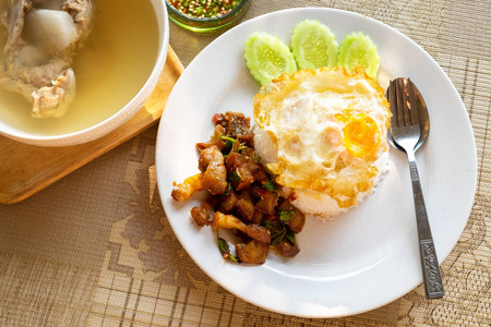 脆猪肉肚和虾与泰国罗勒米与炒鸡蛋在上面。 非常著名和美味的泰国菜在桌子上。