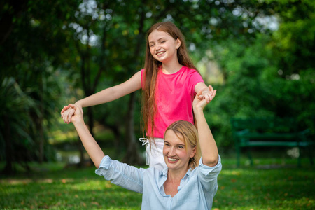 个轻松快乐的母亲和小女儿在户外公共公园. 父母和孩子的概念.