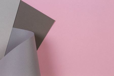 抽象几何形状柔和的粉红色和灰色彩色纸背景