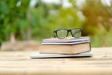 软焦点复古风格的书籍和眼镜与自然背景。 阅读和教育理念。