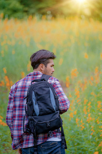 年轻人带着背包在大自然和山丘景观中旅行。