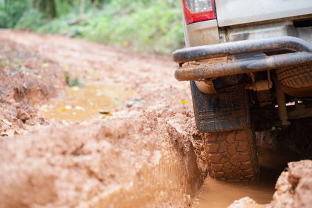 越野车轮胎脏了，SUV在乡村道路上沾满了泥浆。 越野旅行和驾驶概念。