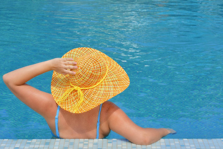 真正的女性美女放松游泳池暑假概念