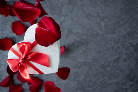 情人节的心形礼盒。 飞红玫瑰花瓣