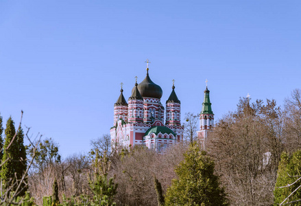 美丽的东正教教堂被树木包围，温暖的秋天下午，潘泰莱蒙教堂，基辅，乌克兰。